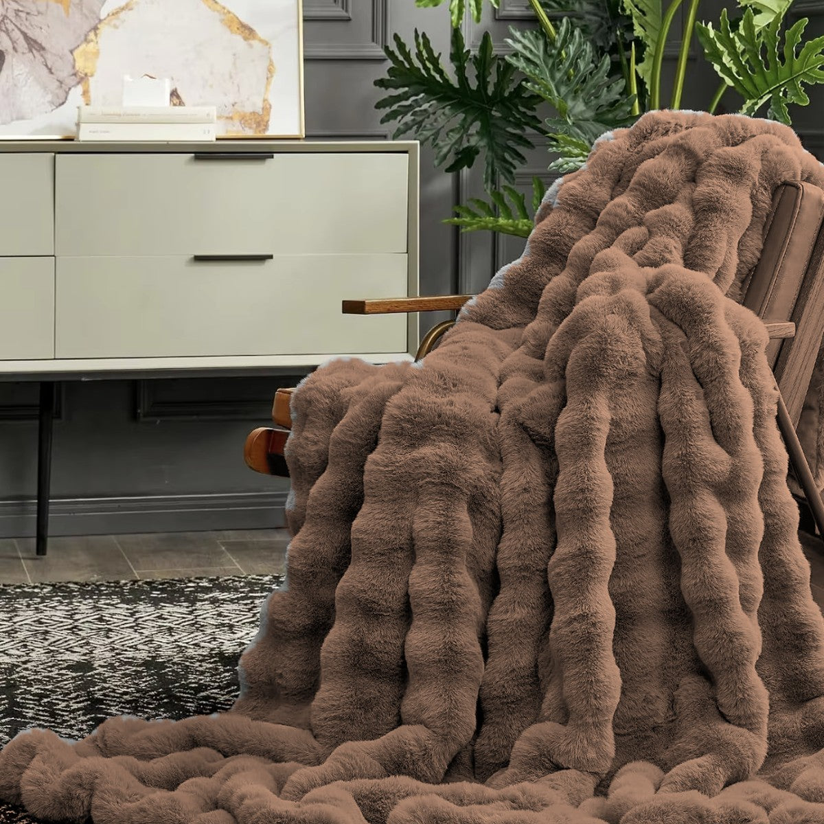 Slumi Kuscheldecke aus Plüsch in Mocha auf dem Sessel