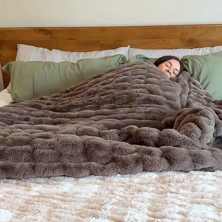 Frau liegt unter der Slumi im Doppelbett